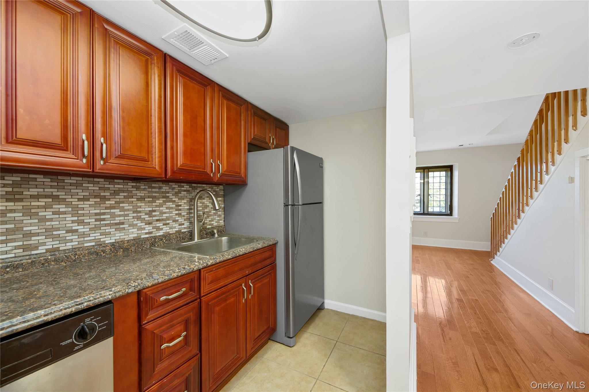 305 Chateau Rive, Unit 305 Peekskill, NY 10566 - Photo 13 of 22 Kitchen featuring stainless steel appliances, backsplash, light wood-type flooring, and reddish brown cabinets