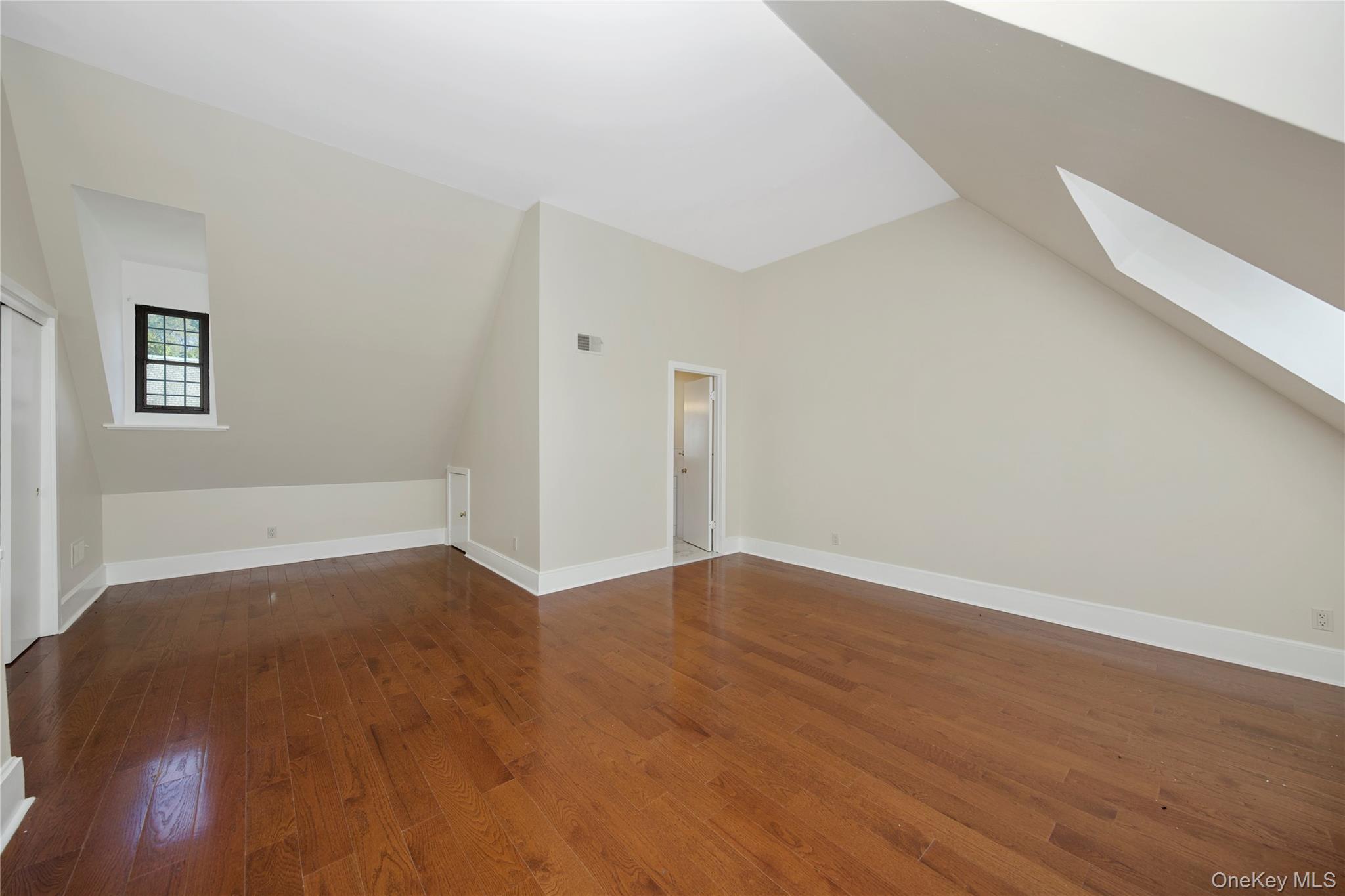305 Chateau Rive, Unit 305 Peekskill, NY 10566 - Photo 6 of 22 Bonus room with a skylight, dark wood finished floors, and lofted ceiling