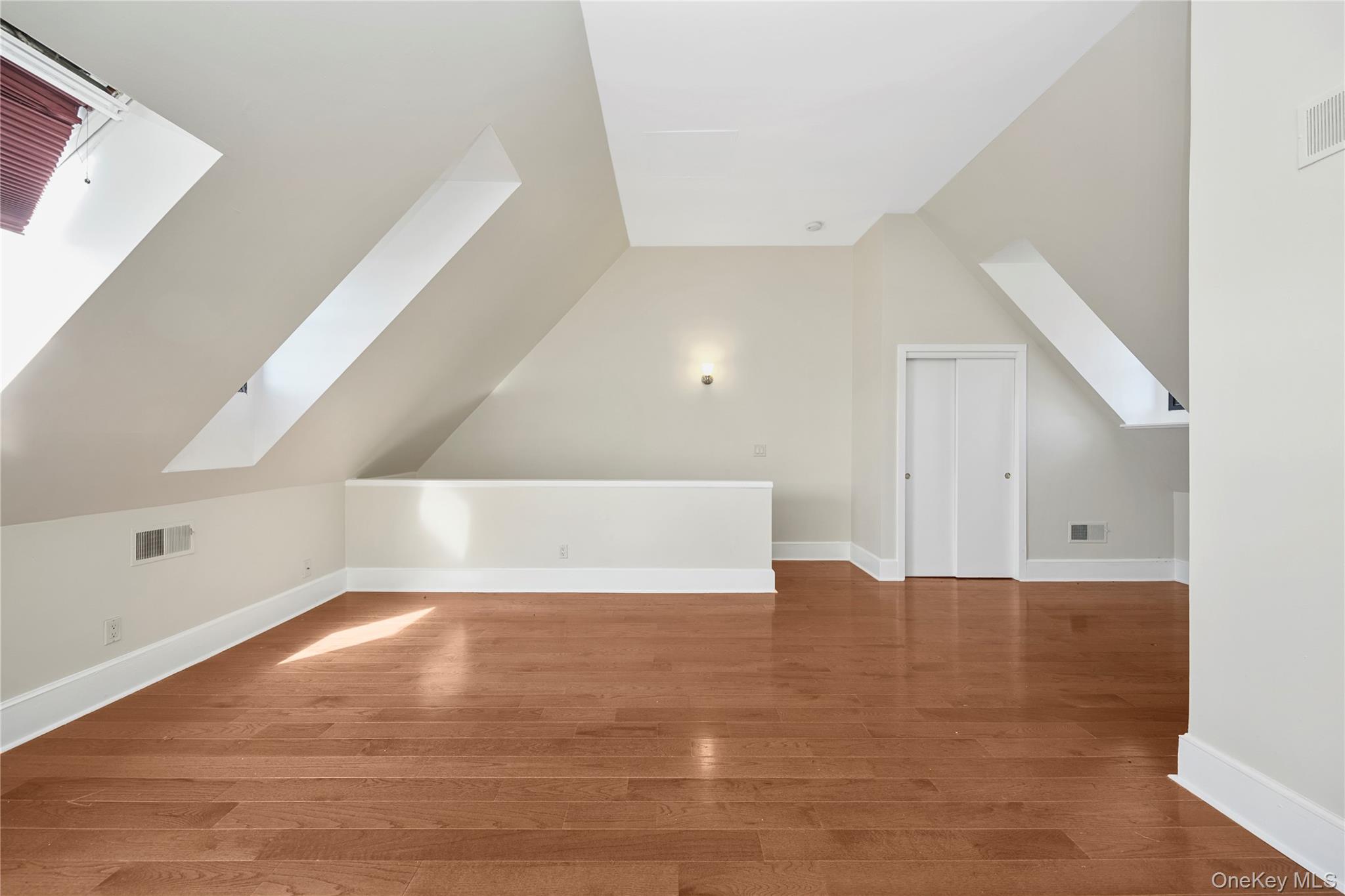 305 Chateau Rive, Unit 305 Peekskill, NY 10566 - Photo 8 of 22 Additional living space featuring a skylight, wood finished floors, and vaulted ceiling