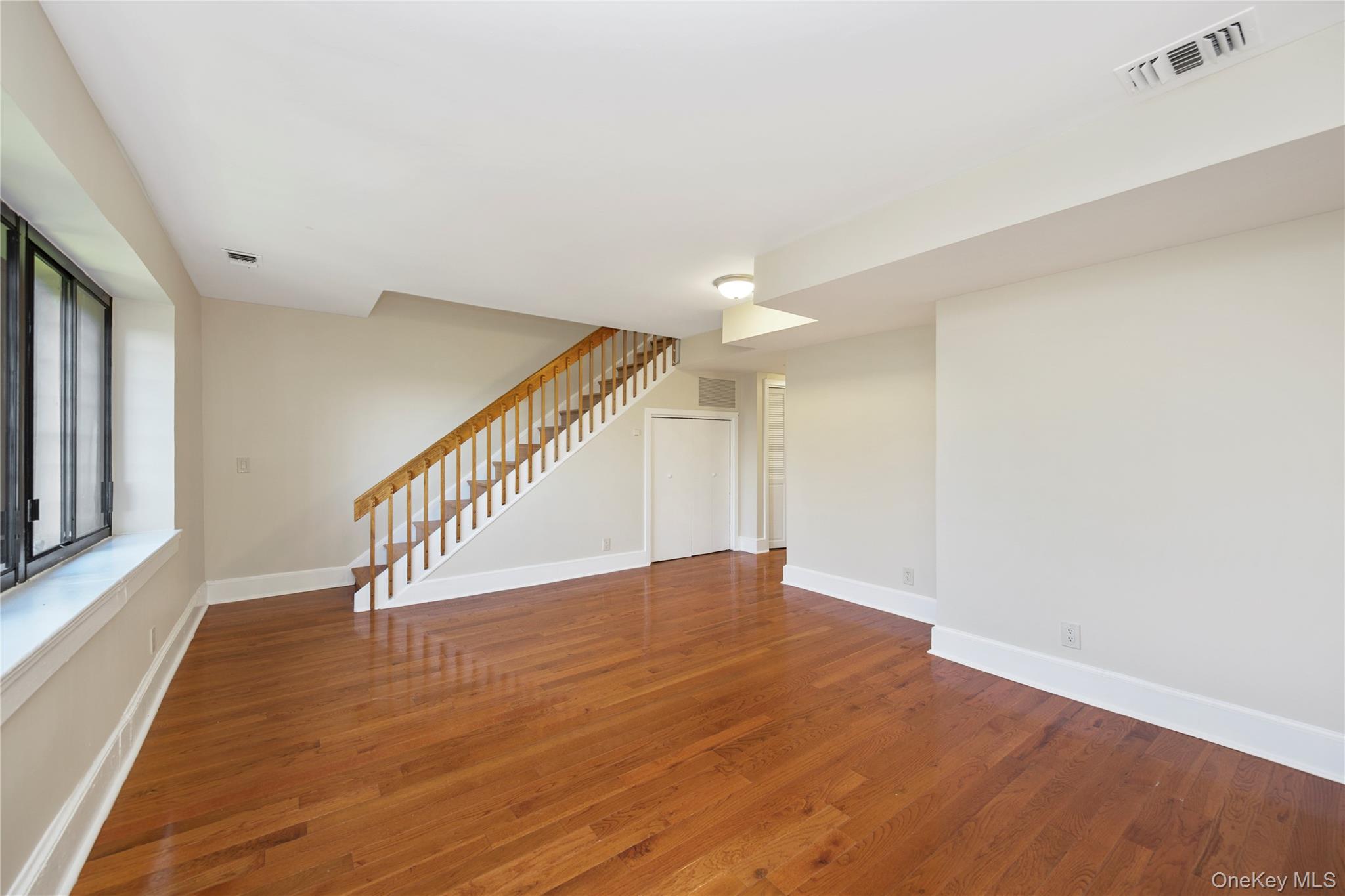 305 Chateau Rive, Unit 305 Peekskill, NY 10566 - Photo 9 of 22 Unfurnished living room with stairs and wood finished floors
