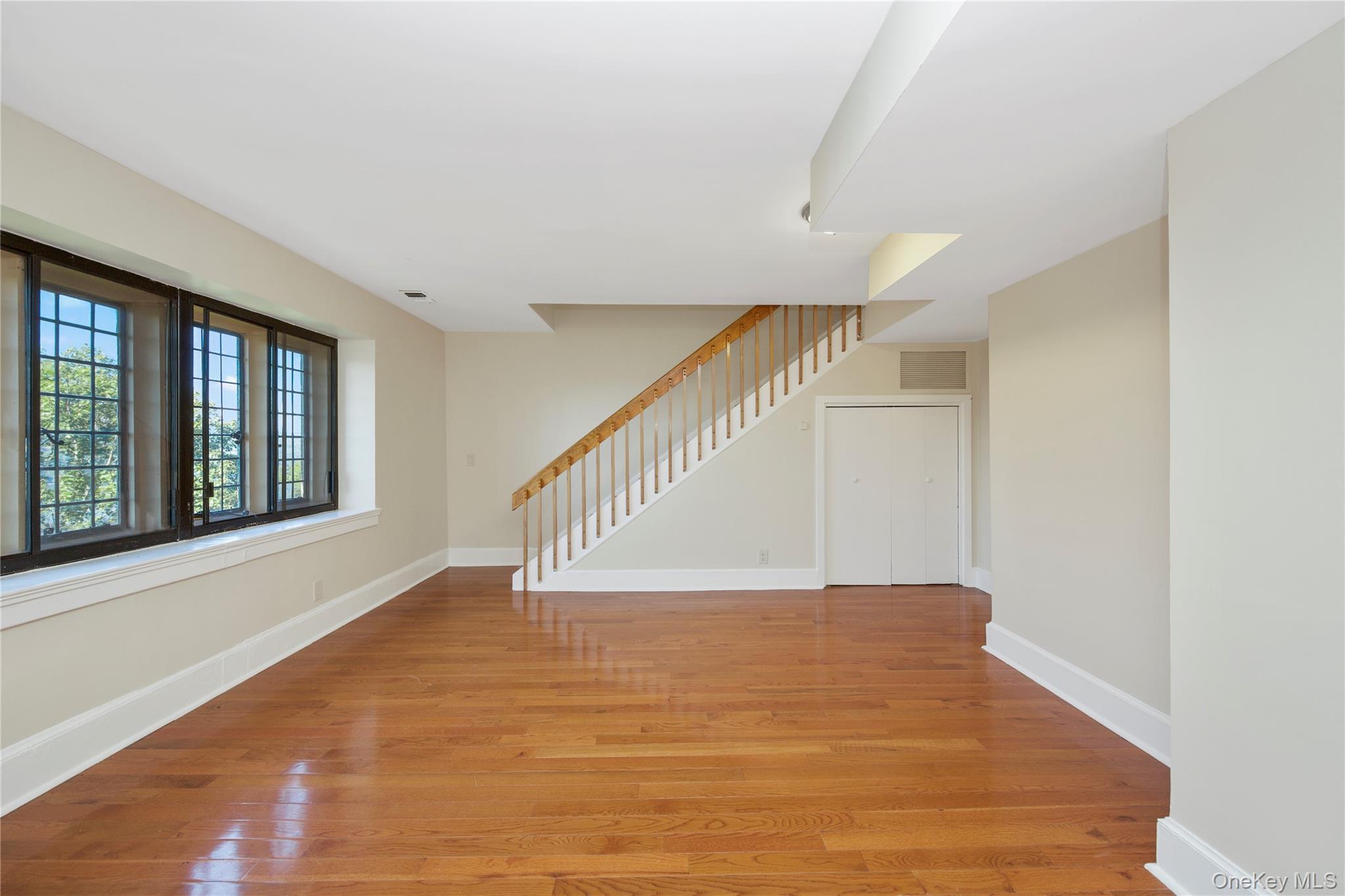 305 Chateau Rive, Unit 305 Peekskill, NY 10566 - Photo 10 of 22 Unfurnished living room featuring stairway and light wood finished floors