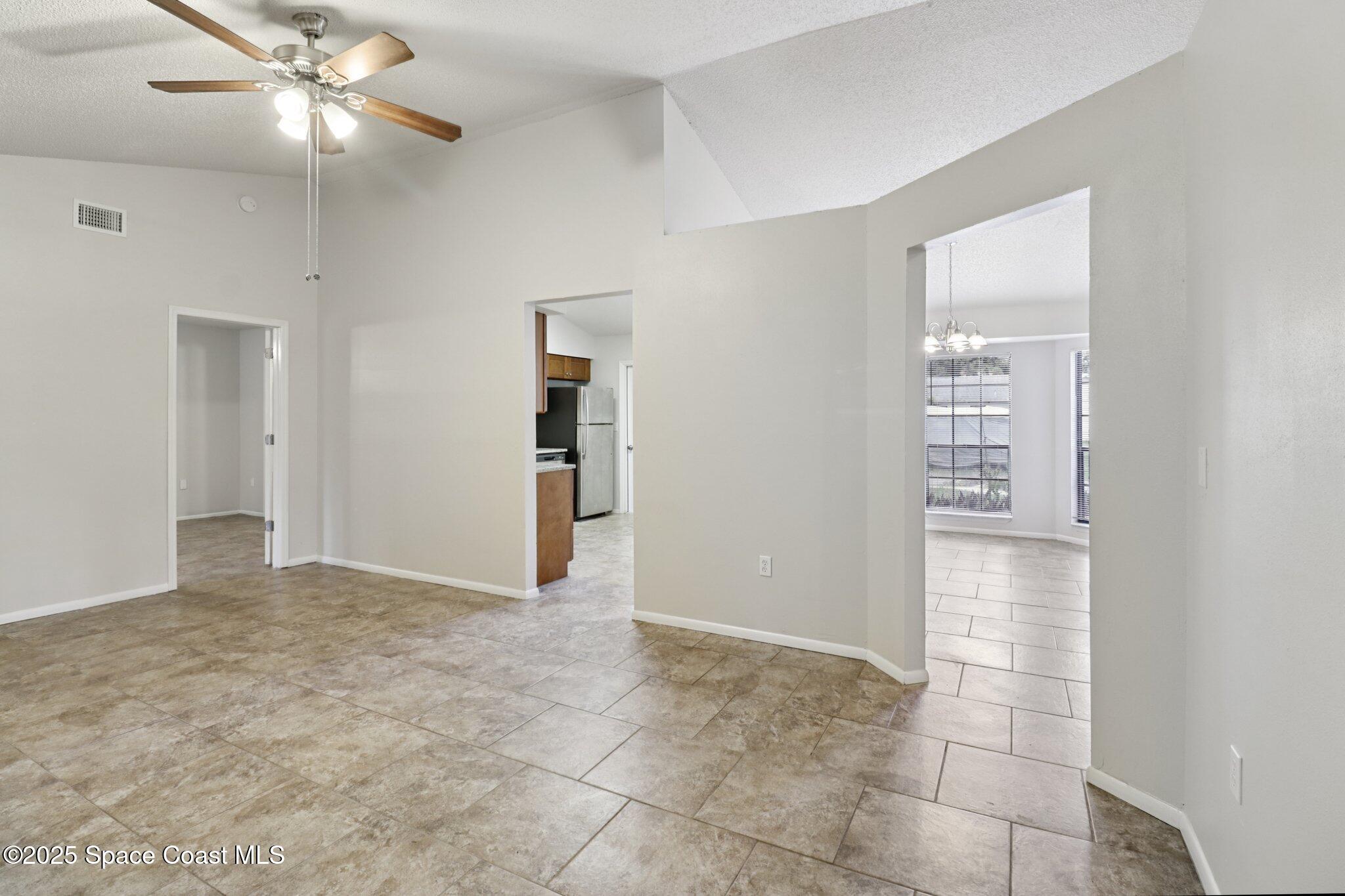 5215 Holden Road Cocoa, FL 32927 - Photo 11 of 34 a view of an empty room with closet and a chandelier fan