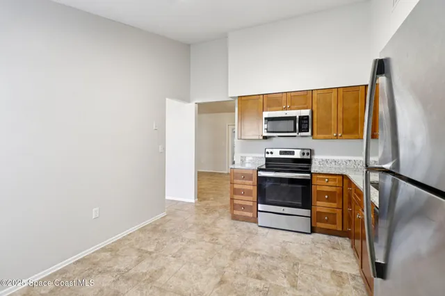 a kitchen with stainless steel appliances granite countertop a refrigerator and a sink
