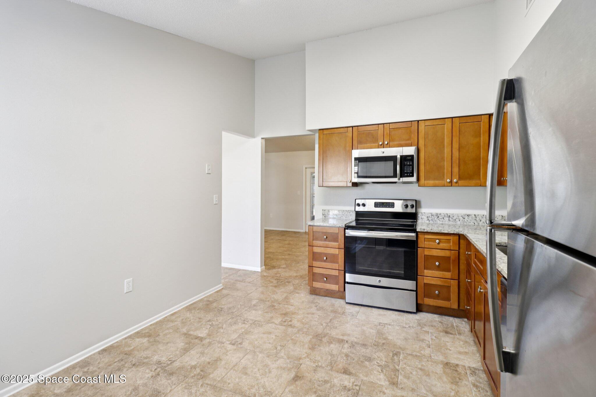 5215 Holden Road Cocoa, FL 32927 - Photo 17 of 34 a kitchen with granite countertop a stove and a refrigerator