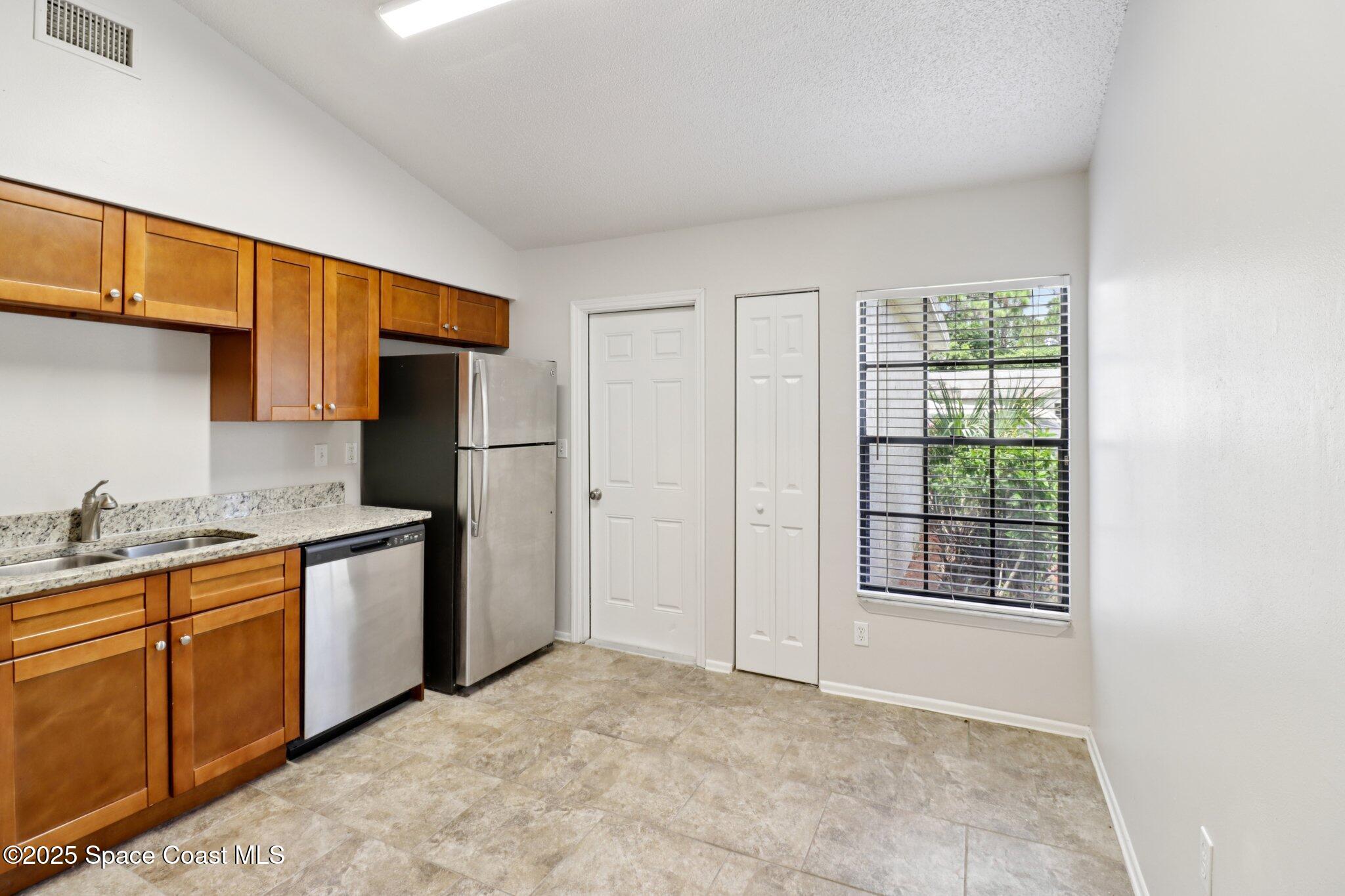 5215 Holden Road Cocoa, FL 32927 - Photo 18 of 34 a kitchen with stainless steel appliances granite countertop a refrigerator and a sink