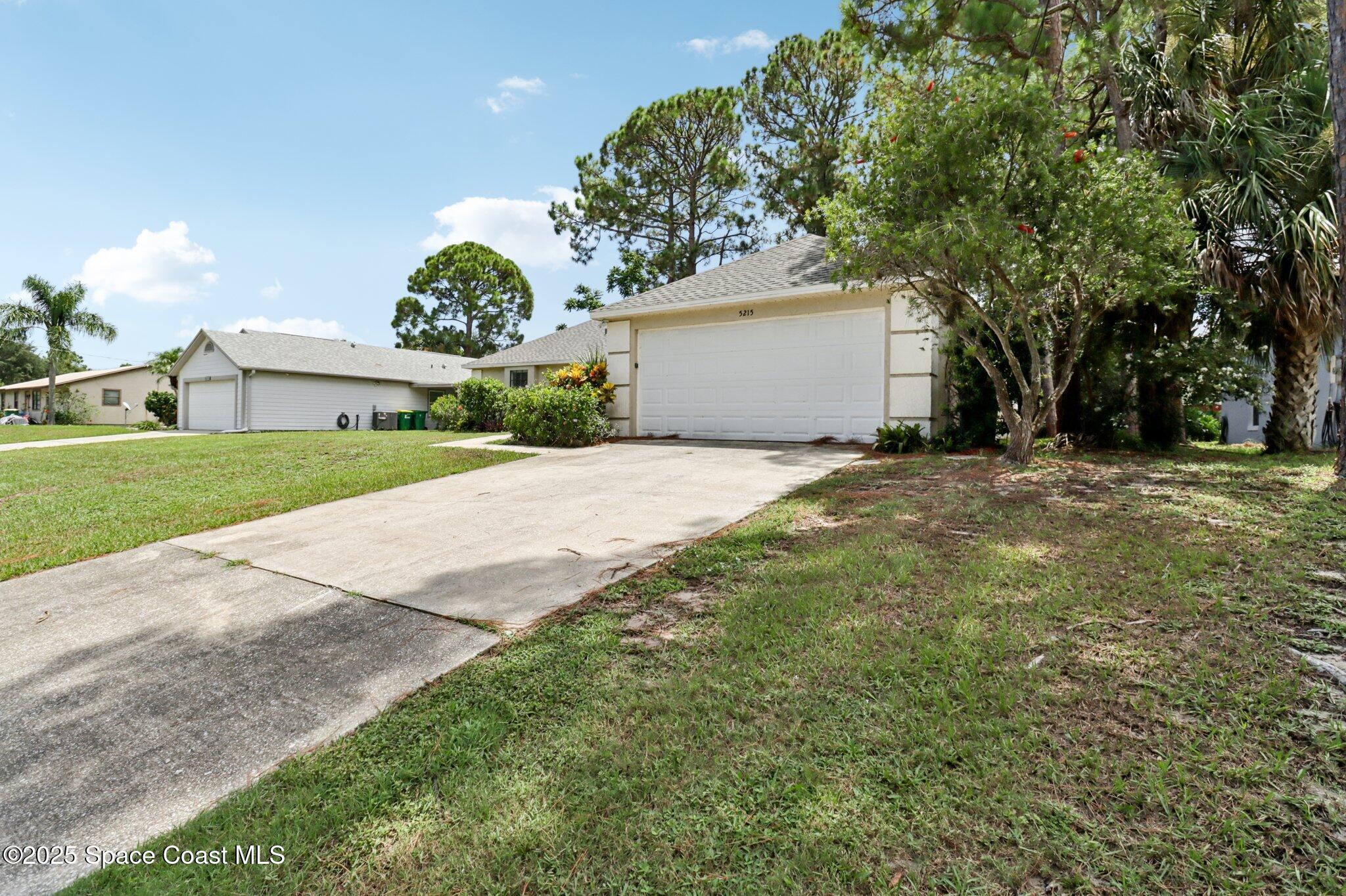 5215 Holden Road Cocoa, FL 32927 - Photo 2 of 34 a view of a house with a yard and garage