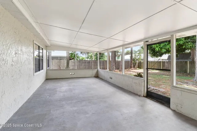 a view of an empty room with a balcony and large windows