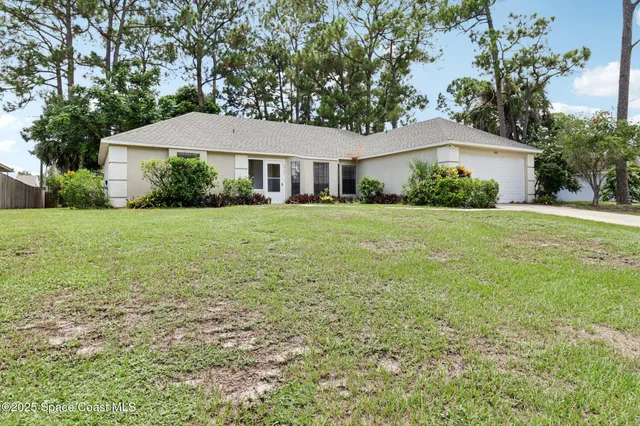 a front view of a house with a yard and trees