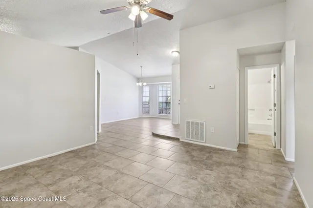 a view of a livingroom with a chandelier & a window