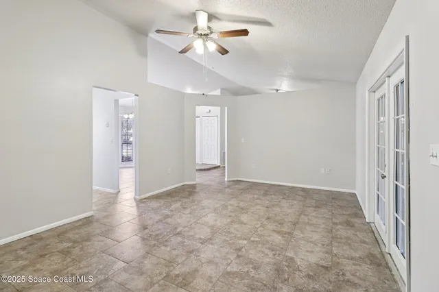 a view of an empty room with closet and a chandelier fan