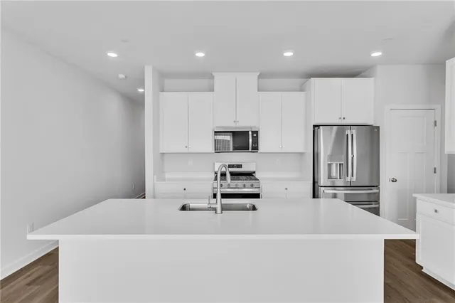 a white kitchen with stainless steel appliances