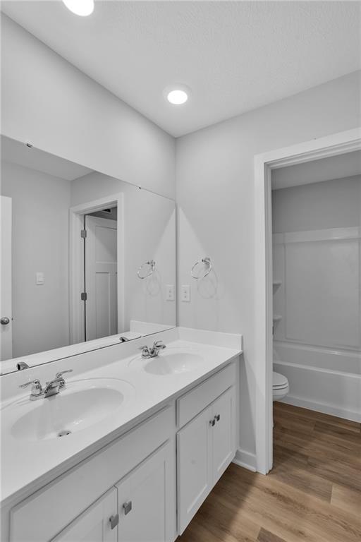126 Scotland Lane Harmony, PA 16037 - Photo 28 of 43 a bathroom with a double vanity sink and mirror with wooden floor