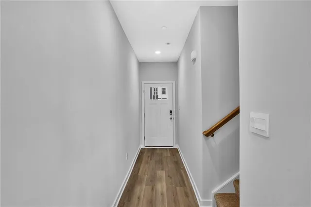 a view of a hallway with wooden floor and staircase