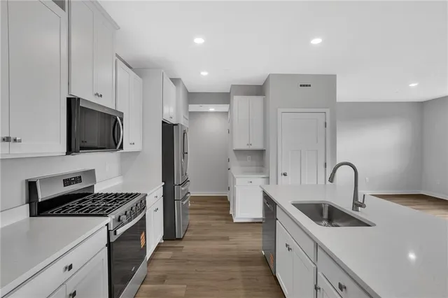 a kitchen with stainless steel appliances granite countertop a sink stove and refrigerator