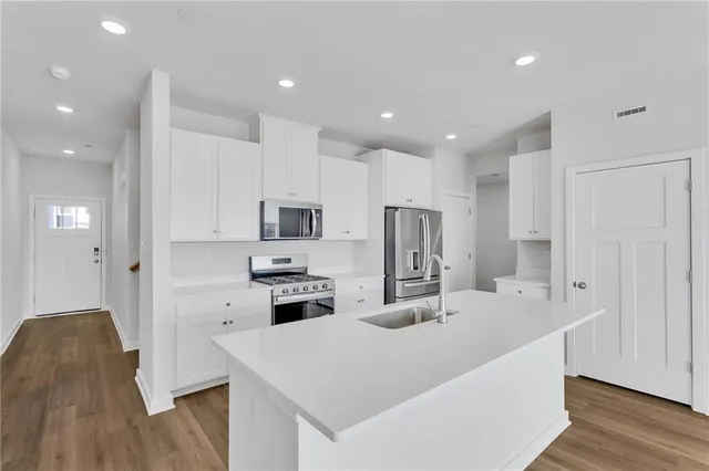 a kitchen with stainless steel appliances a refrigerator sink and microwave