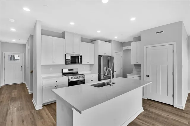 a kitchen with stainless steel appliances a refrigerator sink and microwave