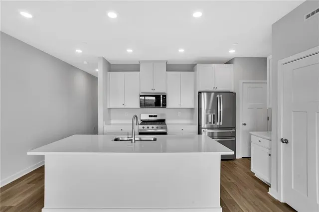 a kitchen with stainless steel appliances a refrigerator and a stove top oven