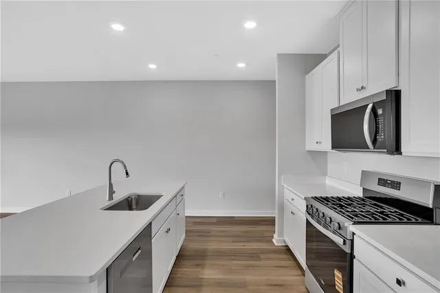 a kitchen with stainless steel appliances a sink a stove and a microwave