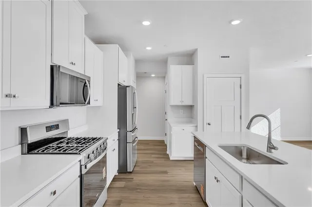 a kitchen with stainless steel appliances granite countertop a sink stove and refrigerator