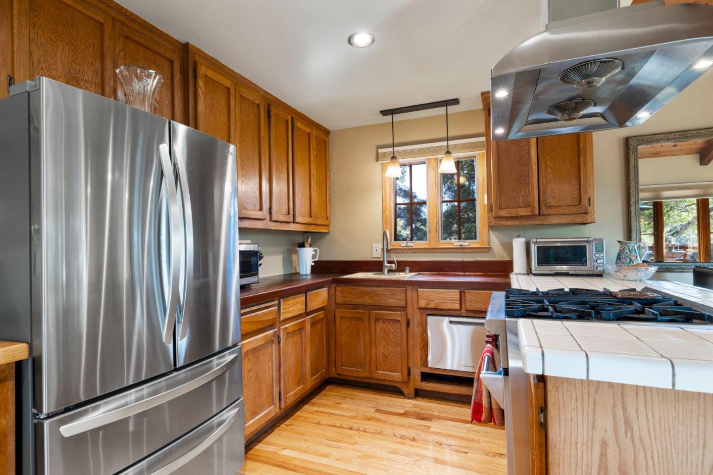 4710 North Rodeo Gulch Road Soquel, CA 95073 - Photo 12 of 97 a kitchen with stainless steel appliances granite countertop a refrigerator a sink dishwasher a stove and white countertops with wooden floor