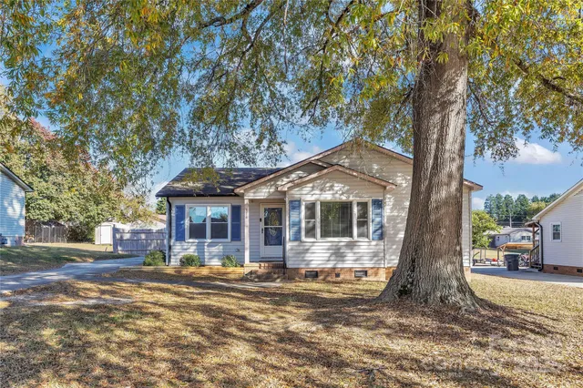 a front view of a house with a tree in it