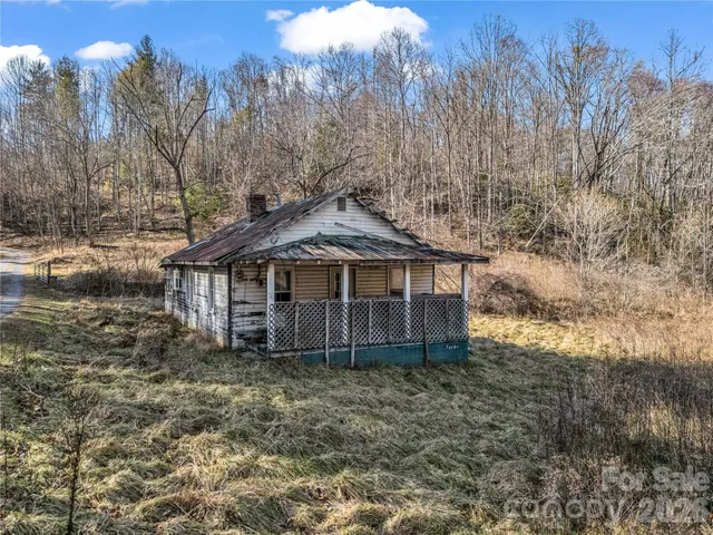 a view of a house with a yard and wooden fence