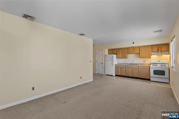 a view of a kitchen with white cabinets and white appliances