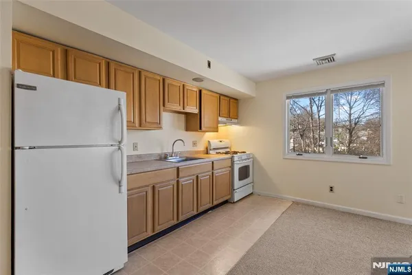 a kitchen with stainless steel appliances a refrigerator sink and cabinets