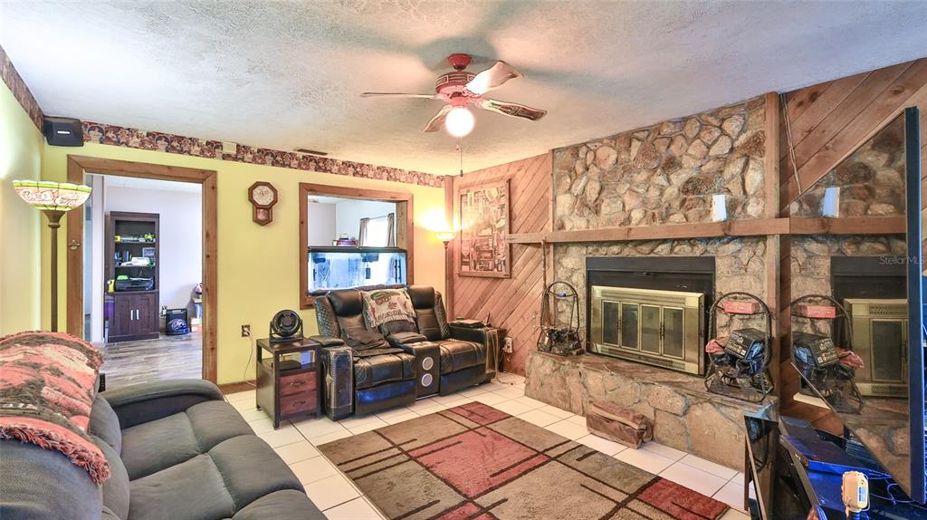 428 Perdita Avenue Edgewater, FL 32132 - Photo 2 of 28 a living room with furniture a fireplace and a chandelier