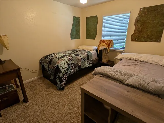 a bedroom with a bed workspace and a window