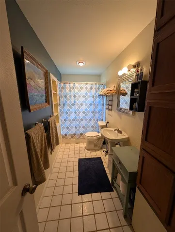 a bathroom with a sink a toilet a mirror and shower