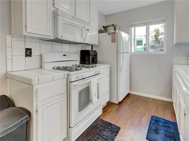 a kitchen with a stove a refrigerator and a window