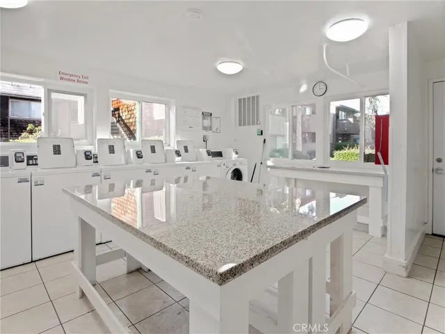 a large kitchen with granite countertop a sink and white cabinets with a large window