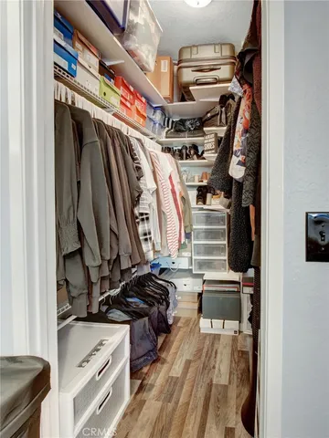 a view of walk in closet with clothes and shoes