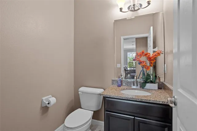 a bathroom with a granite countertop sink a toilet and a mirror