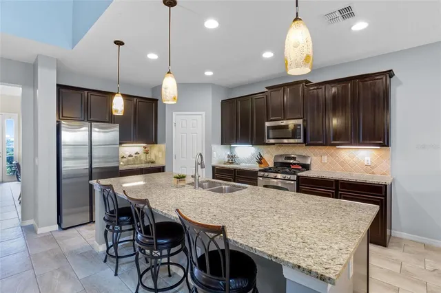a kitchen with stainless steel appliances granite countertop a stove a sink and a refrigerator