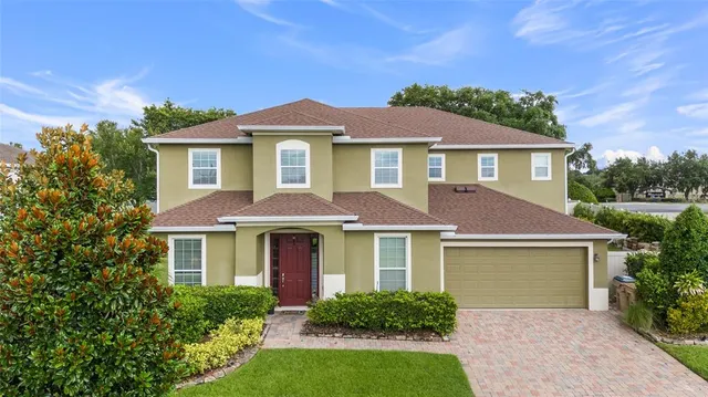 a front view of a house with yard and trees
