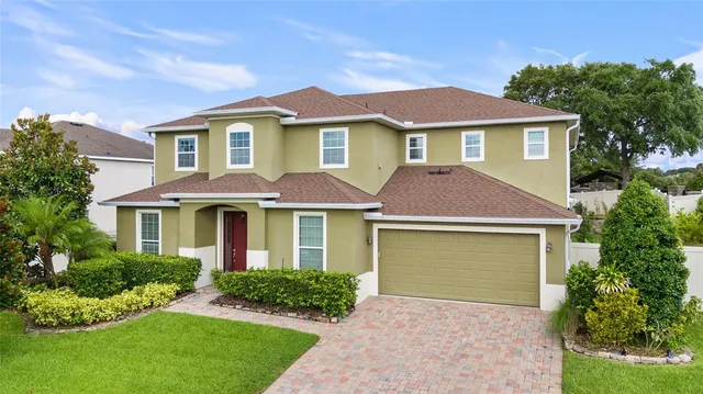 a front view of a house with yard and green space