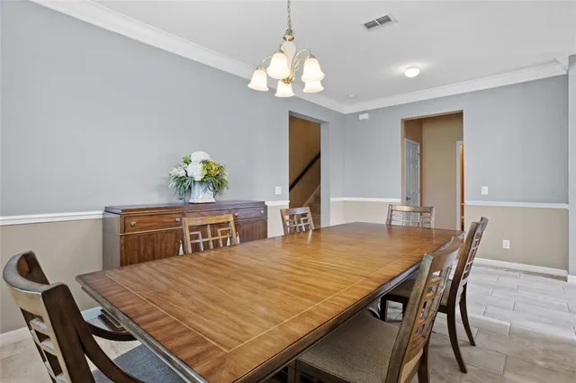 a dining room with a table chairs and a chandelier