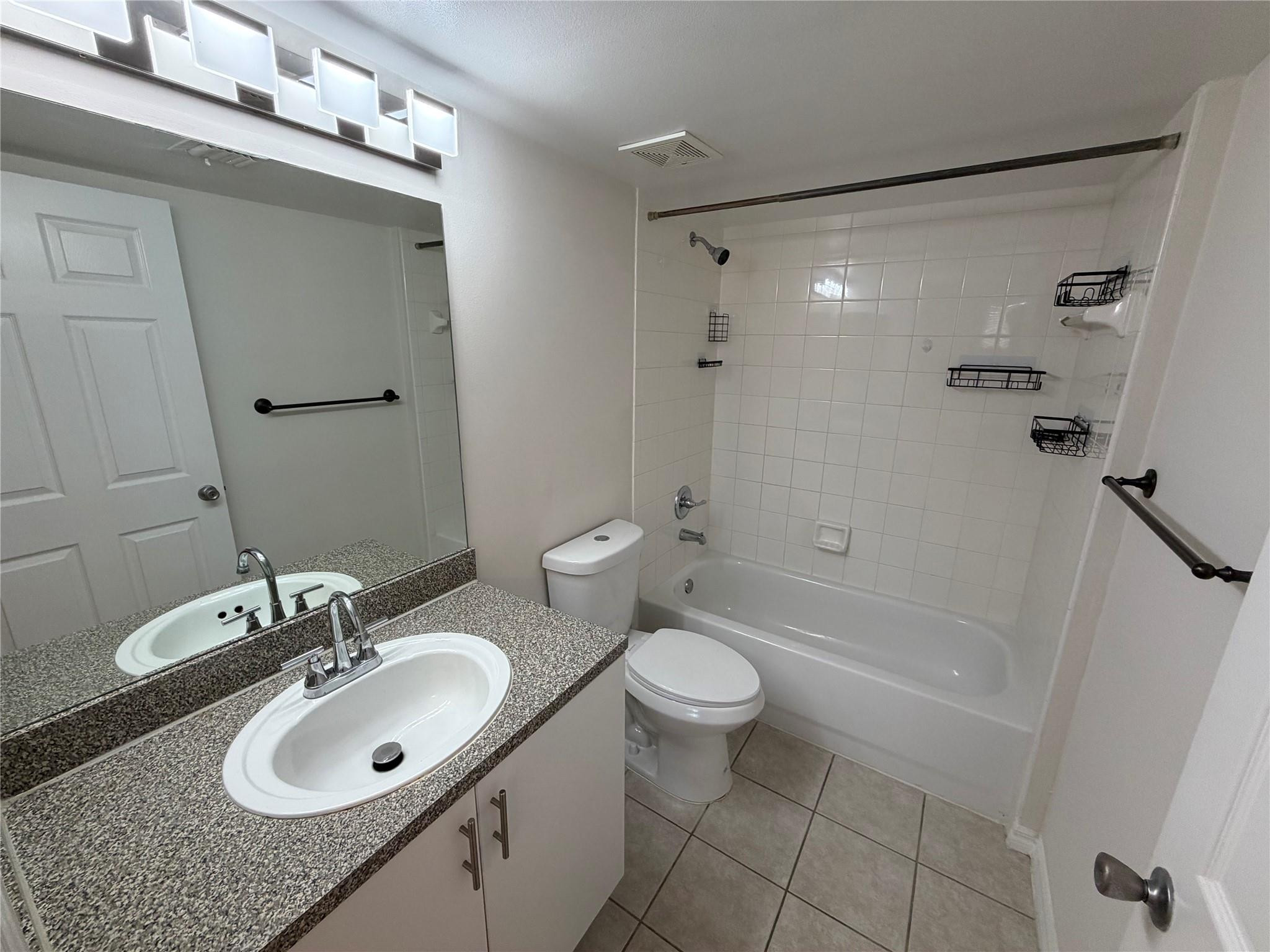 5005 Wiles Road, Unit 307 Pompano Beach, FL 33073 - Photo 13 of 28 a bathroom with a sink toilet a mirror and shower