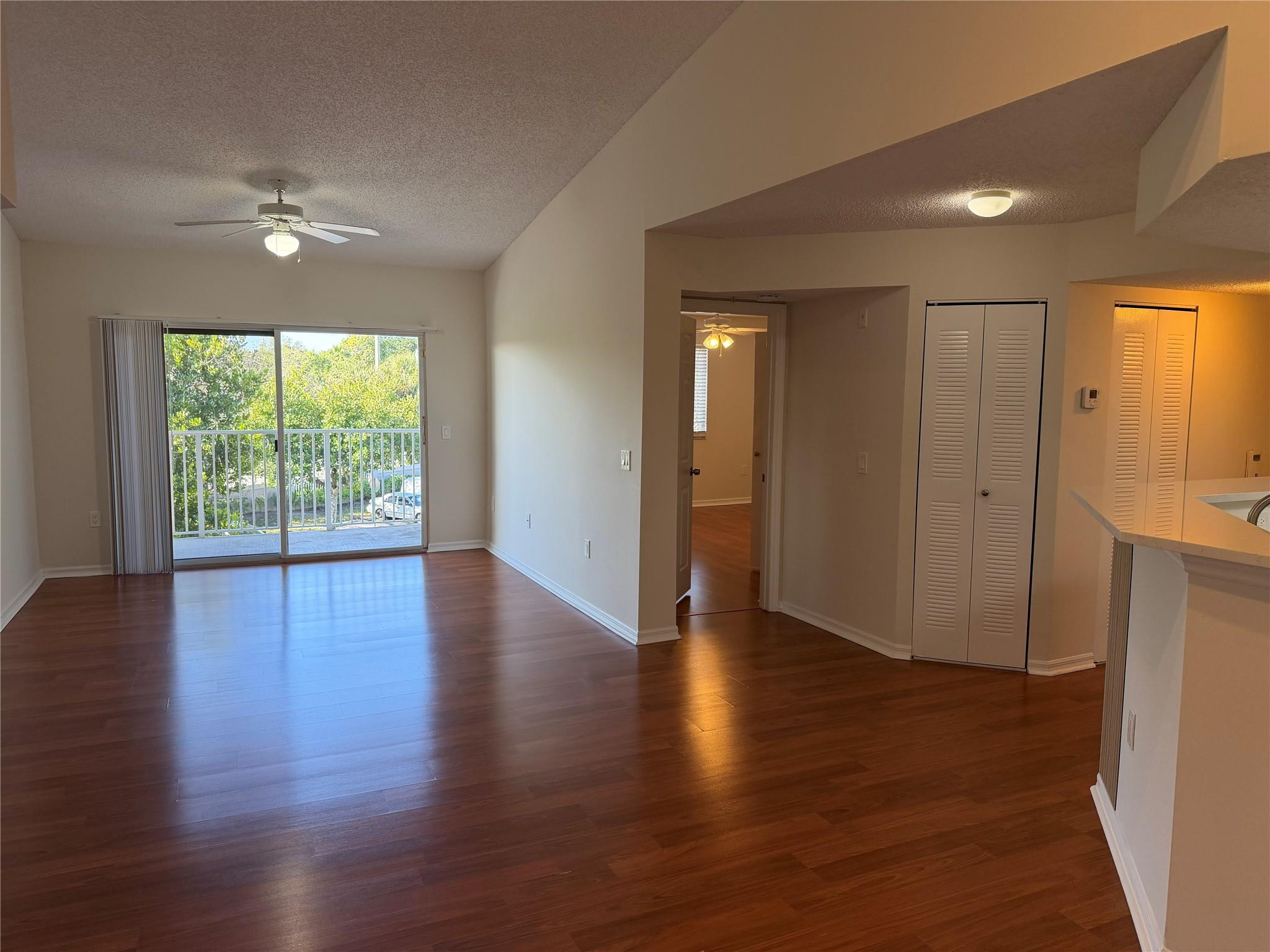 5005 Wiles Road, Unit 307 Pompano Beach, FL 33073 - Photo 2 of 28 a view of empty room with wooden floor and fan