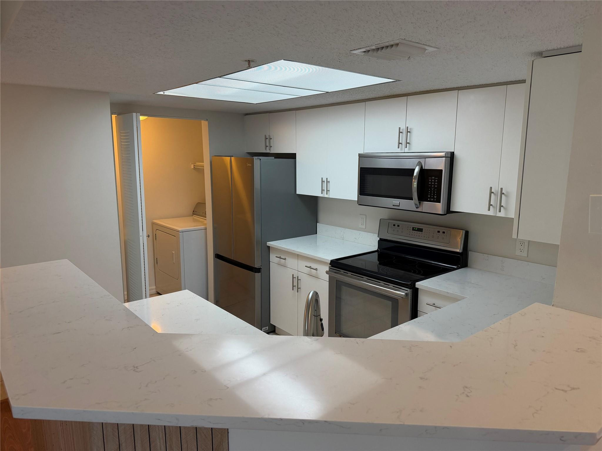 5005 Wiles Road, Unit 307 Pompano Beach, FL 33073 - Photo 6 of 28 a kitchen with a refrigerator stove and microwave