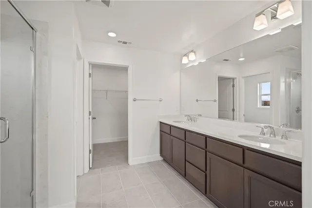a bathroom with a double vanity sink and mirror with shower