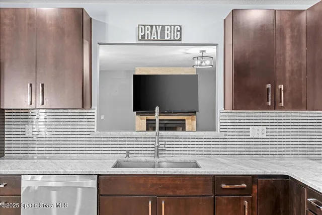 a large kitchen with stainless steel appliances kitchen island granite countertop a refrigerator and a stove top oven