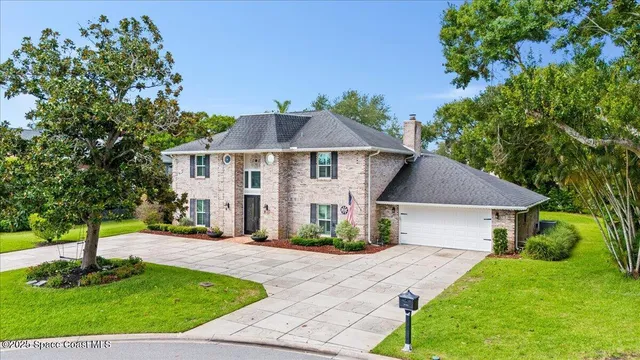 a front view of a house with a yard and potted plants
