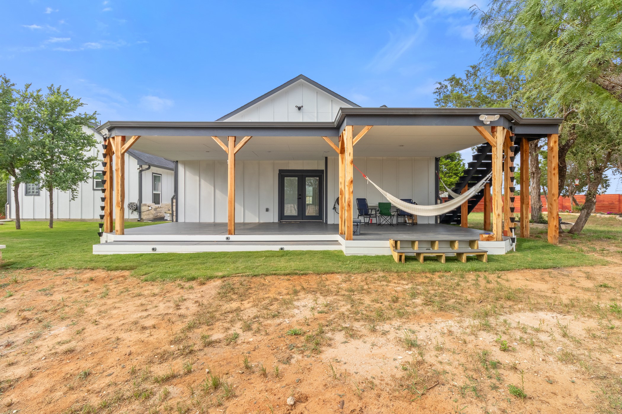 123 Zacate Street Elgin, TX 78621 - Photo 5 of 33 Covered patio featuring exposed wood beams and a dark gray roofline