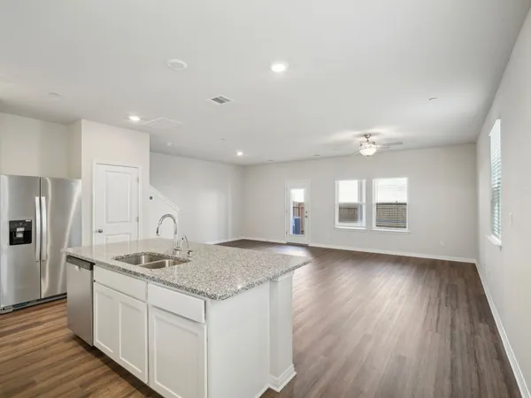 a kitchen with refrigerator a microwave a sink and cabinets