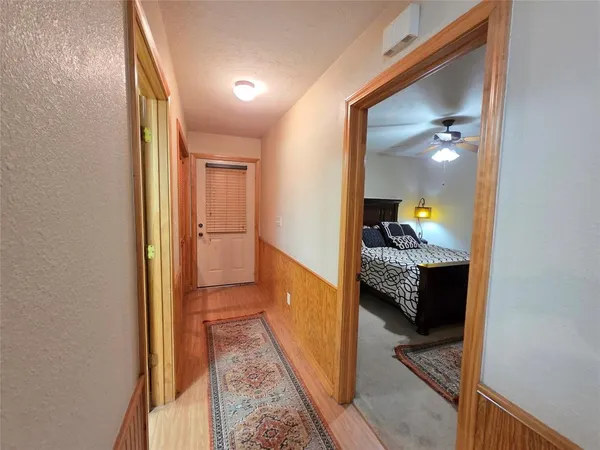 a view of a hallway and a livingroom with furniture