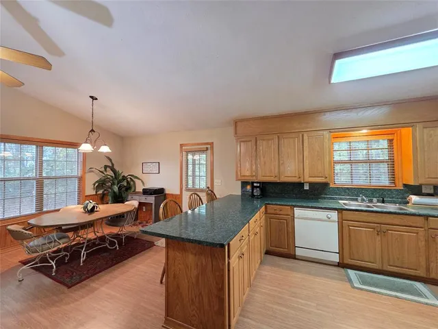 a kitchen with stainless steel appliances a sink counter space cabinets and a large window