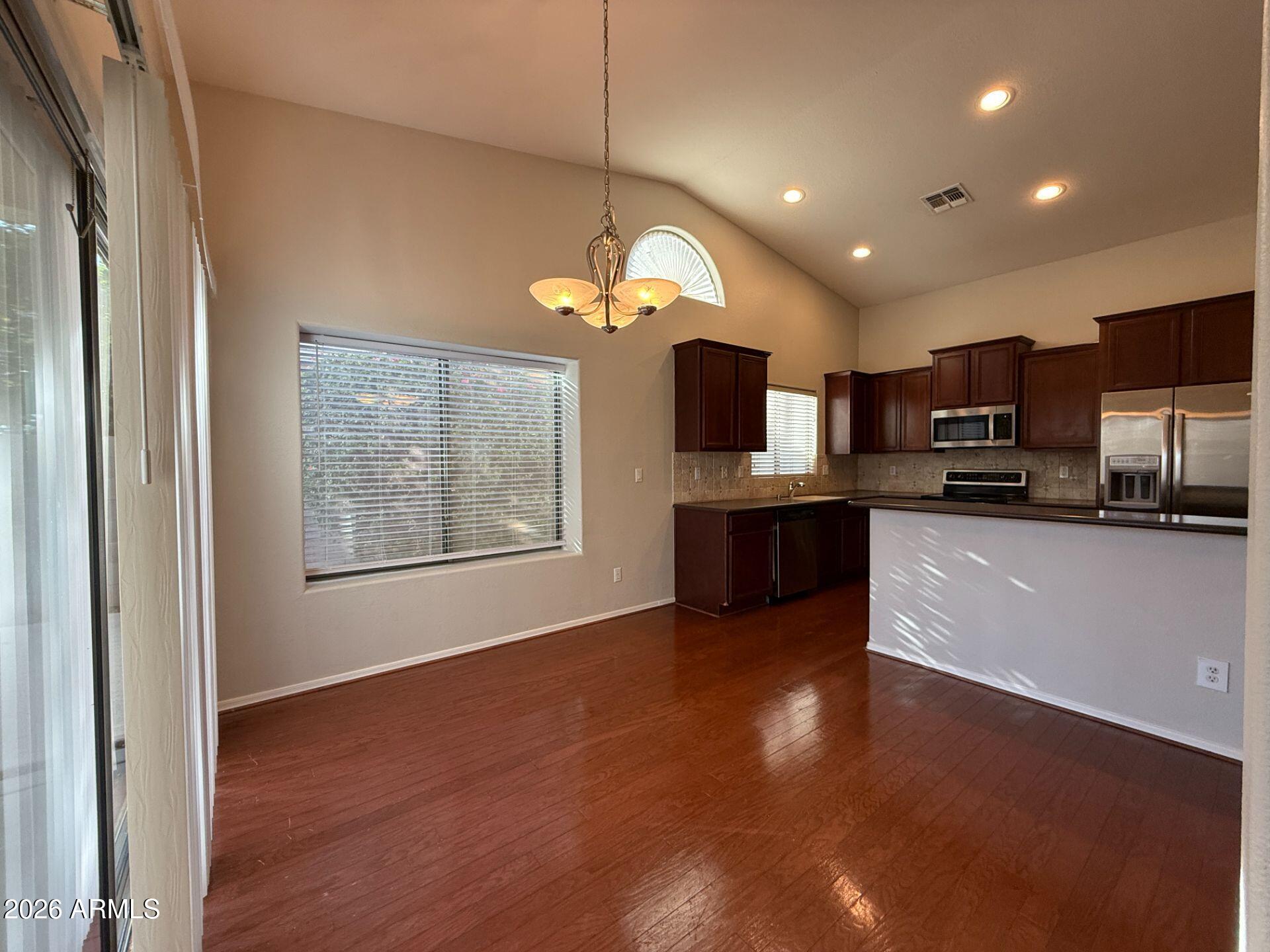 14641 West Hearn Road Surprise, AZ 85379 - Photo 14 of 42 a view of a kitchen with a sink wooden cabinets and a living room